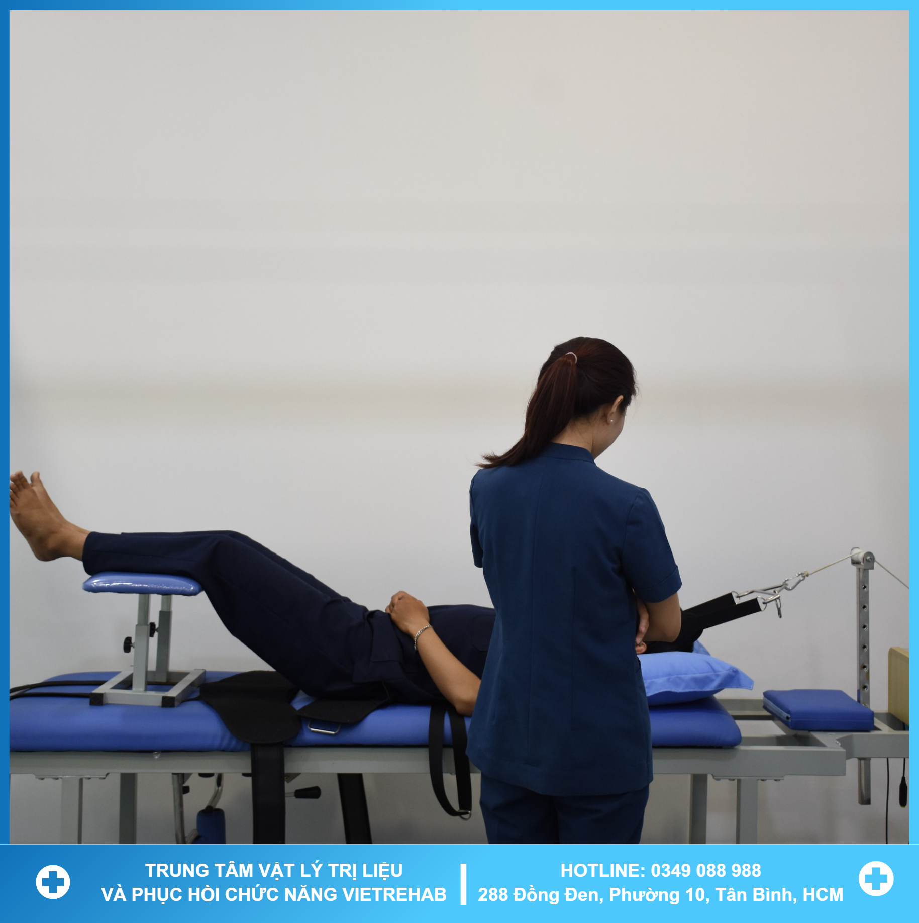 A therapist working with a patient on a rehabilitation machine with greenery in the background